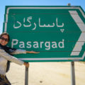 Fernanda segurando a placa de Pasargada na estrada do Irã