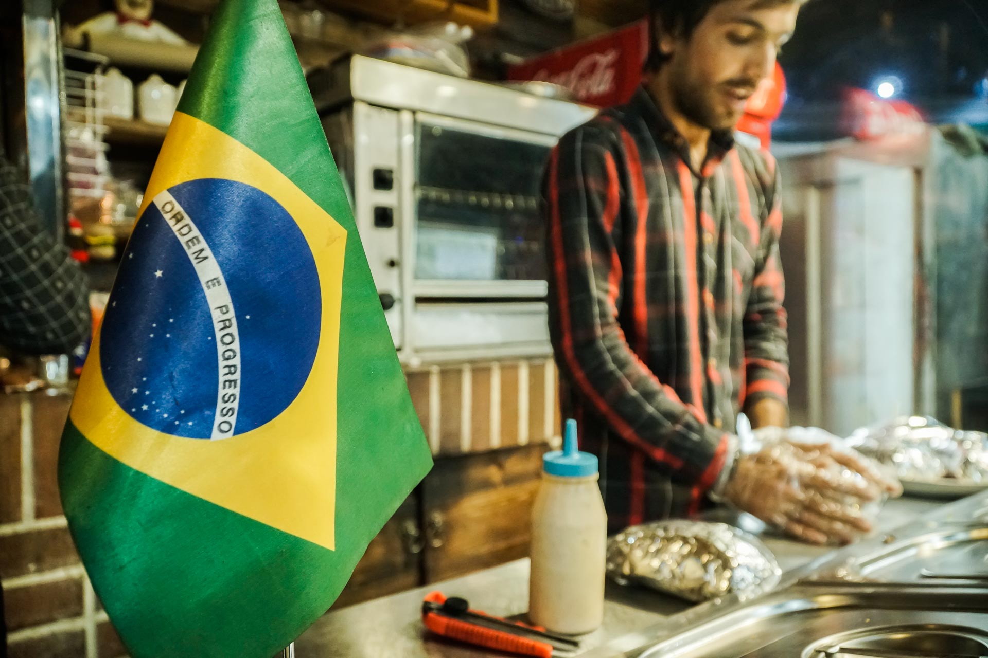 Bandeira do Brasil na frente do Iraniano fazendo um kebab