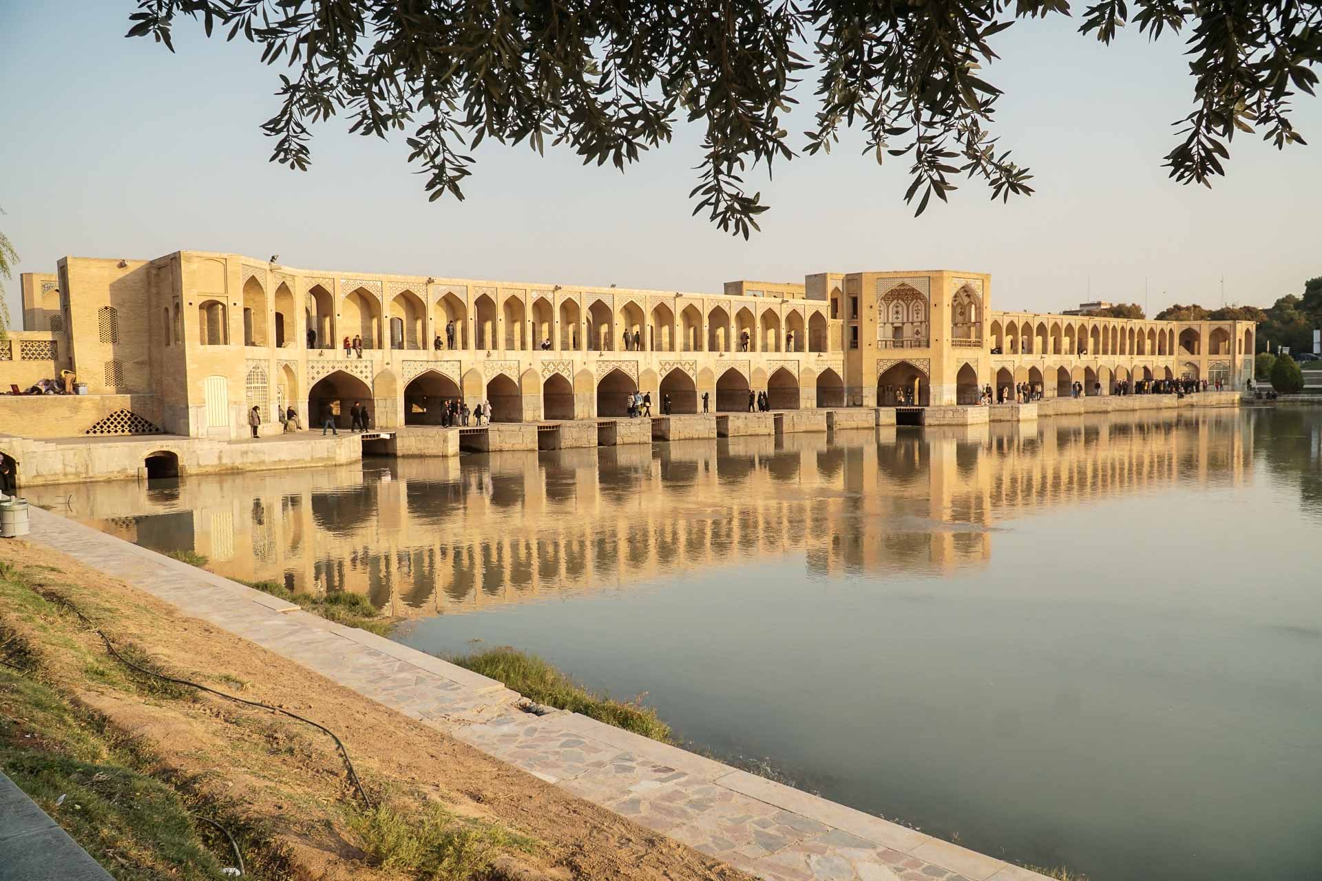 Ponte si o se Pol em Isfahan vista debaixo da árvore com raios da golden hour iluminando