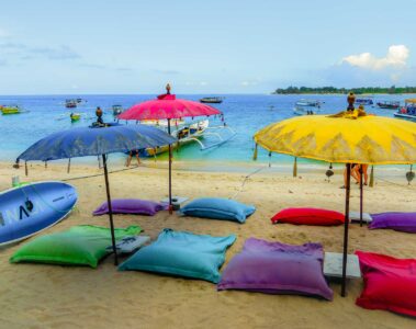 Guarda-sois coloridos e almofadas coloridas na praia de Gili Air