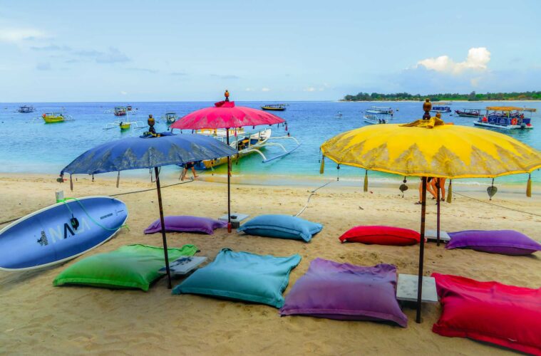 Colourful sunshades and colourful sand pillows on the beach in Gili Air