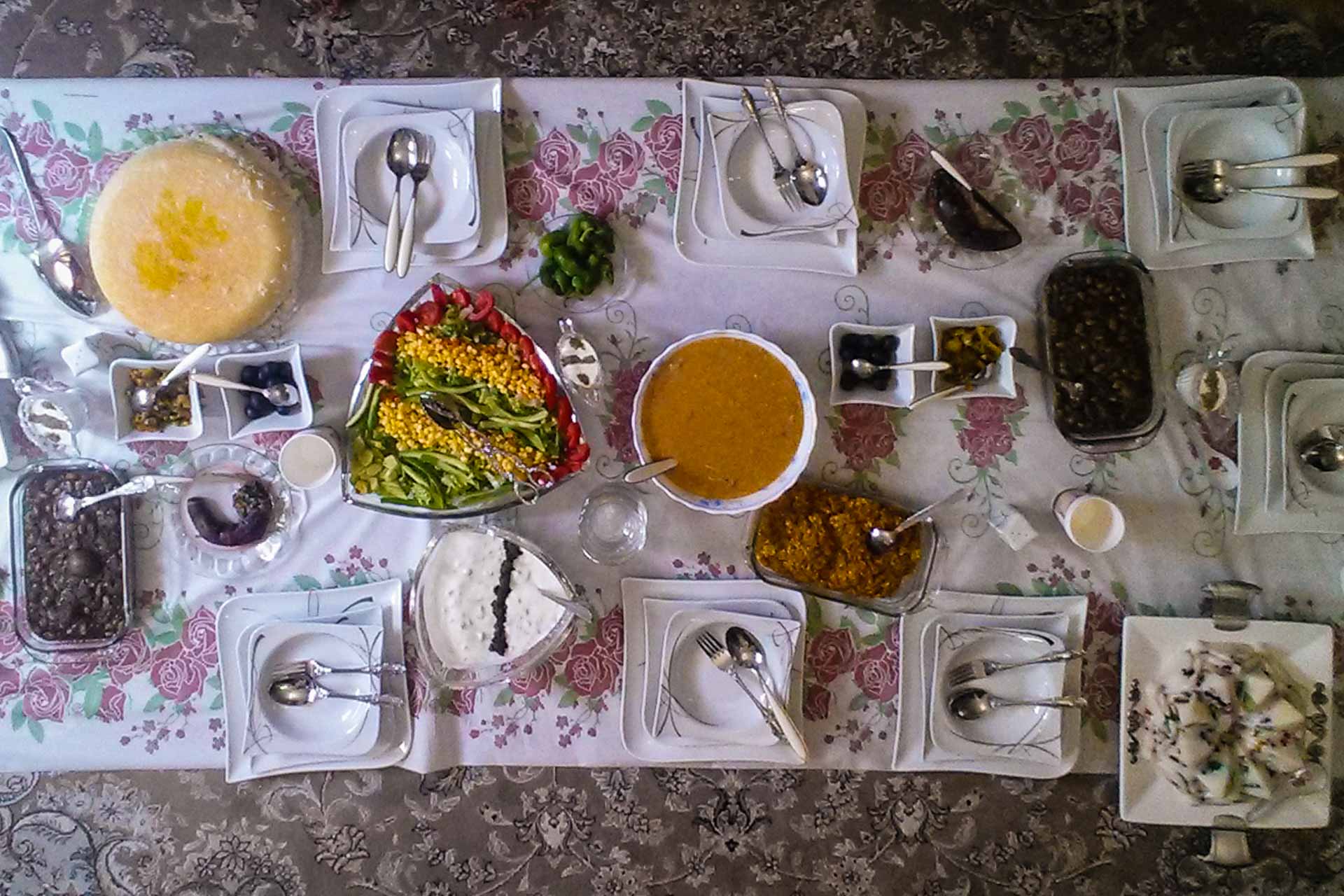 Mesa iraniana posta com pratos típicos no chão em cima da toalha