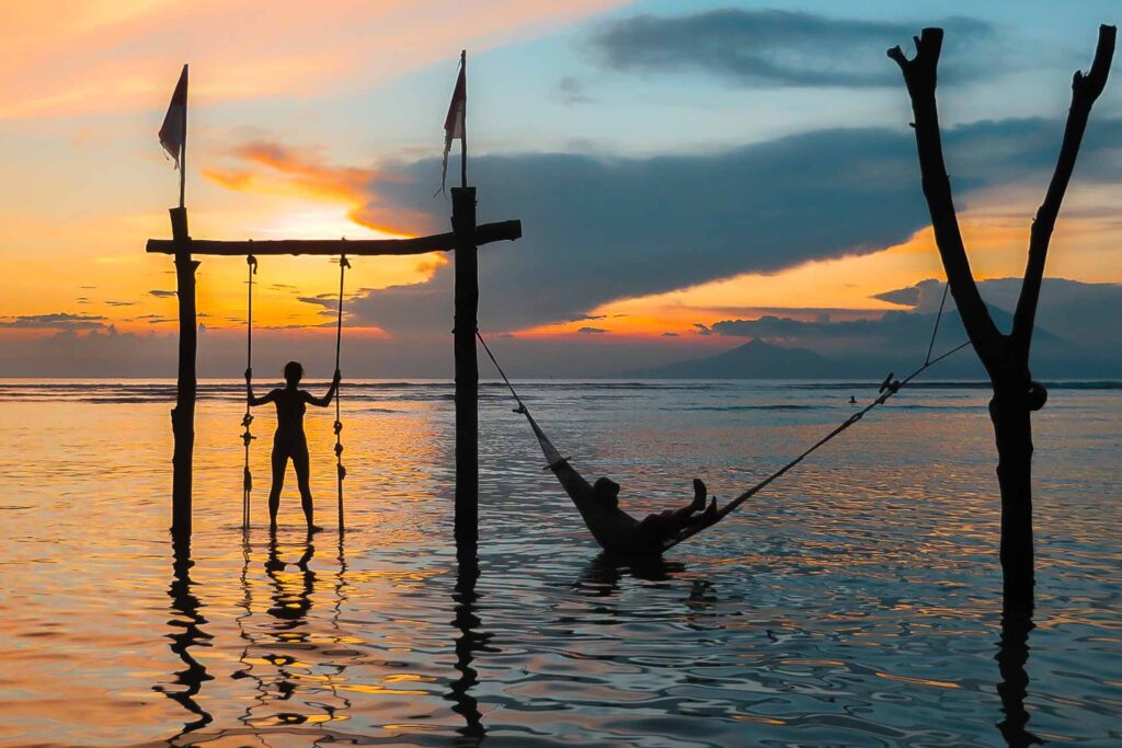 Um balanço e uma rede montados na água da praia das Ilhas Gili