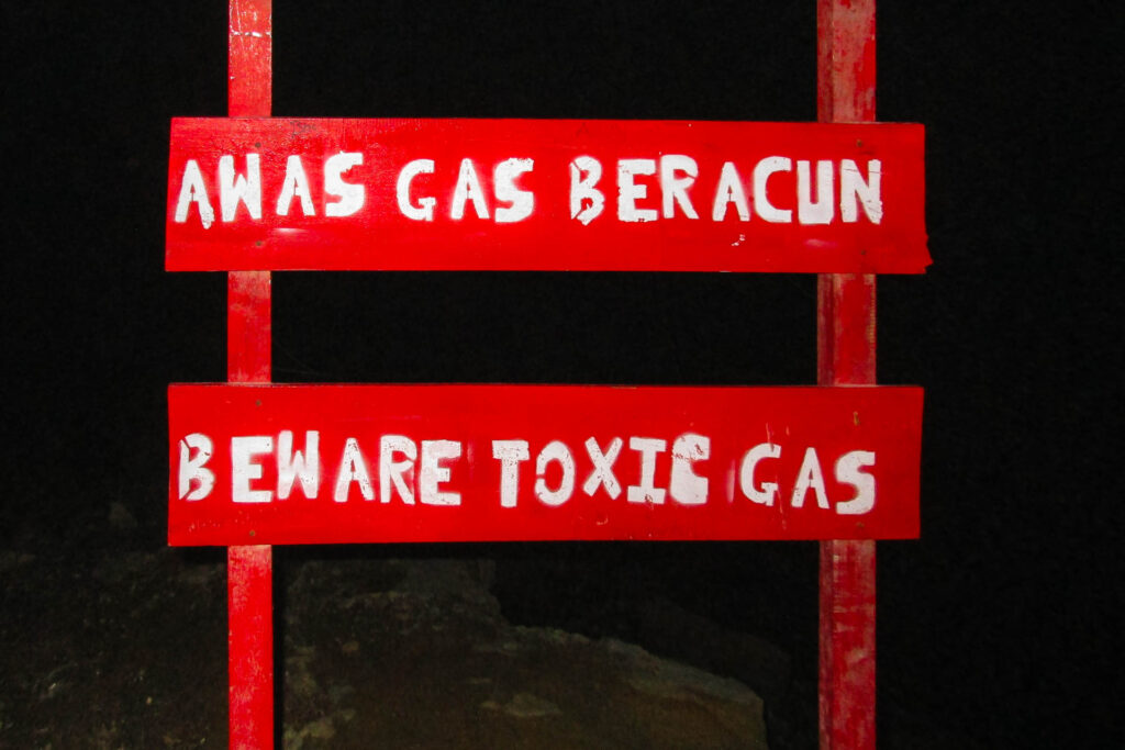 A sign at the entrance of Ijen crater volcano saying to be careful with toxic gas