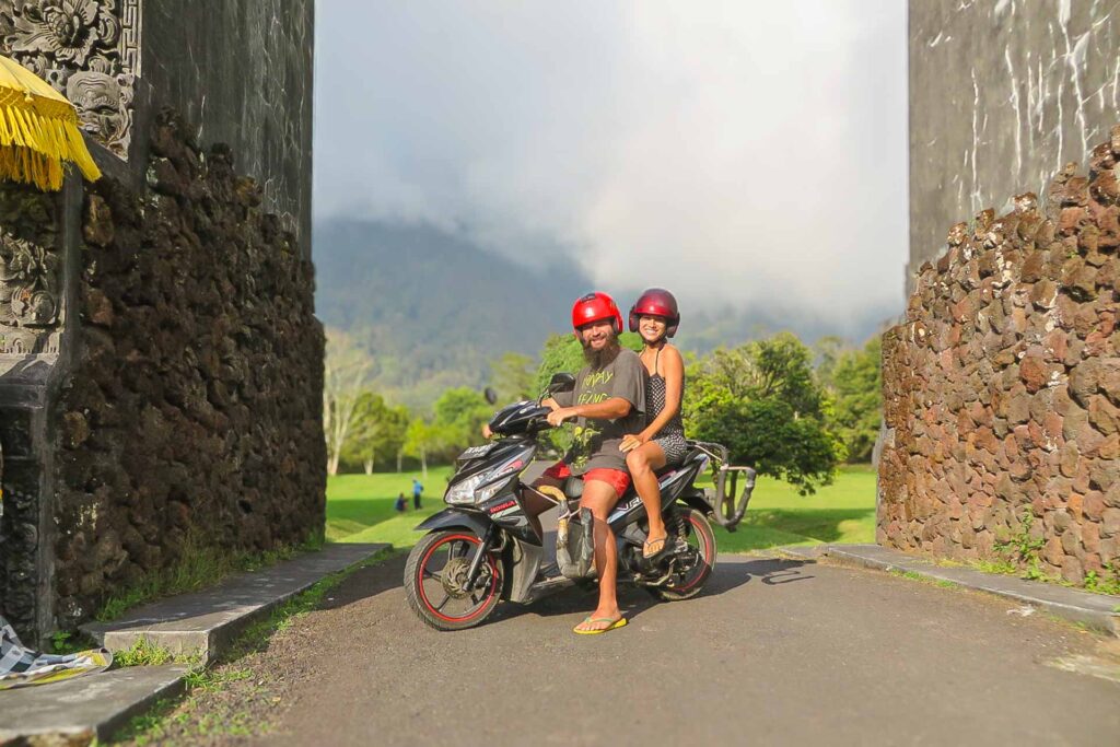 Tiago e Fernanda on a motorbike in Thailand in between two walls
