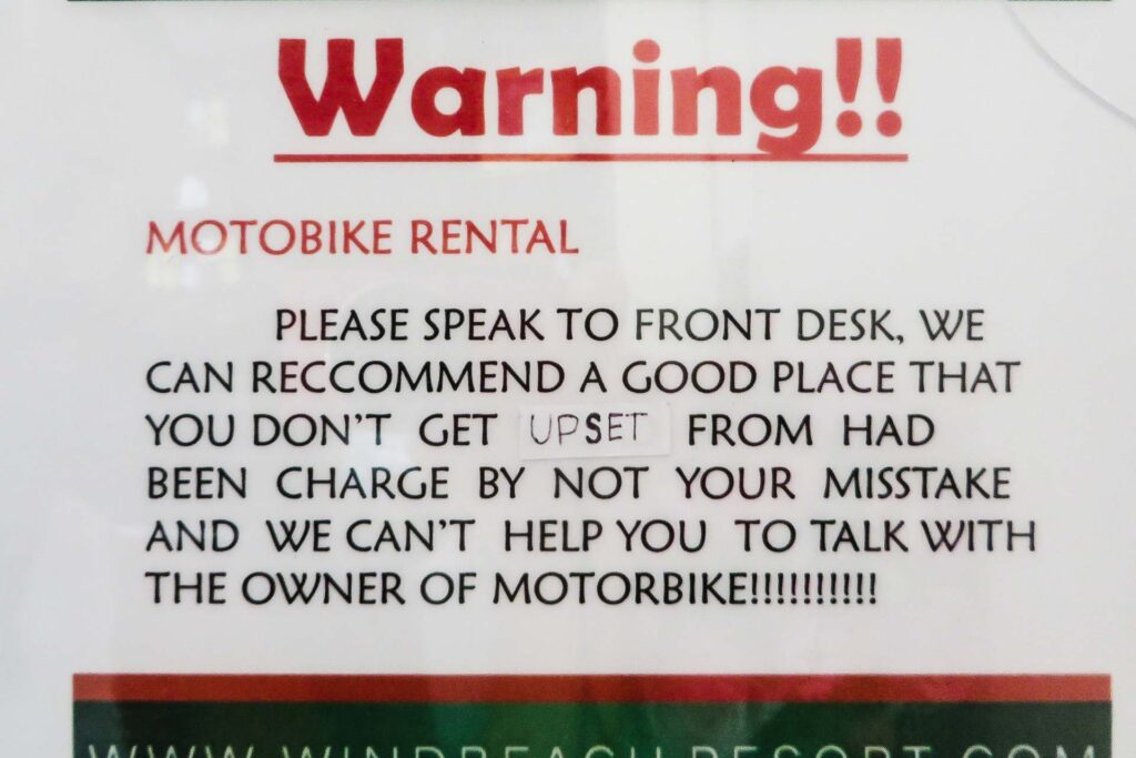 Um aviso no hotel falando que eles te ajudam caso você seja vítima de golpe e recomendando lugares honestos para alugar a sua moto na Tailândia
