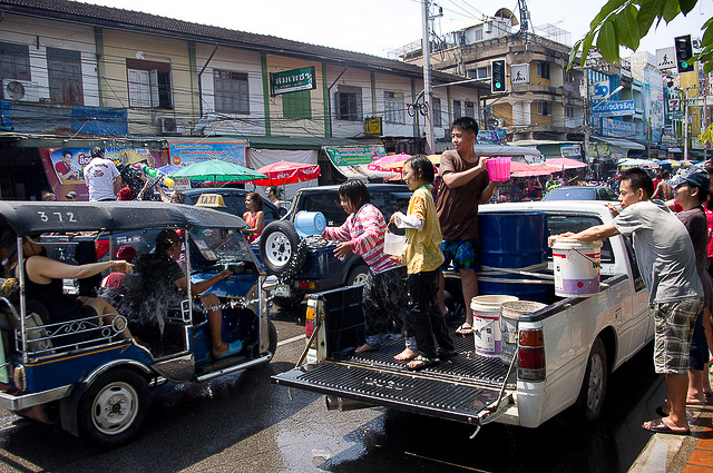 People of top of a pickup car throwing water on traditions for new years day