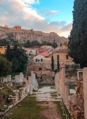 ruins in Athens with the Acropolis on top of the hill in the background
