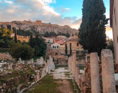 ruins in Athens with the Acropolis on top of the hill in the background