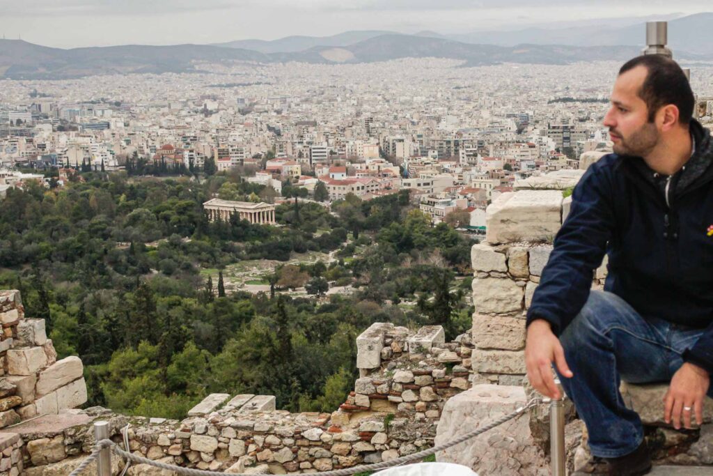 Tiago no topo da montanha olhando para a esquerda onde esta a cidade de Atenas no fundo