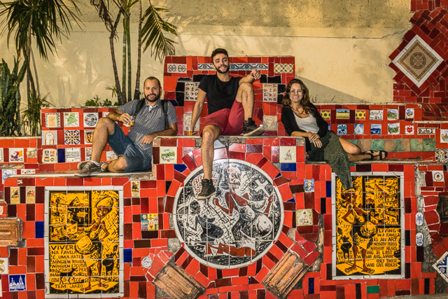 three people sitting on Escadaria Selaron in Rio de Janeiro