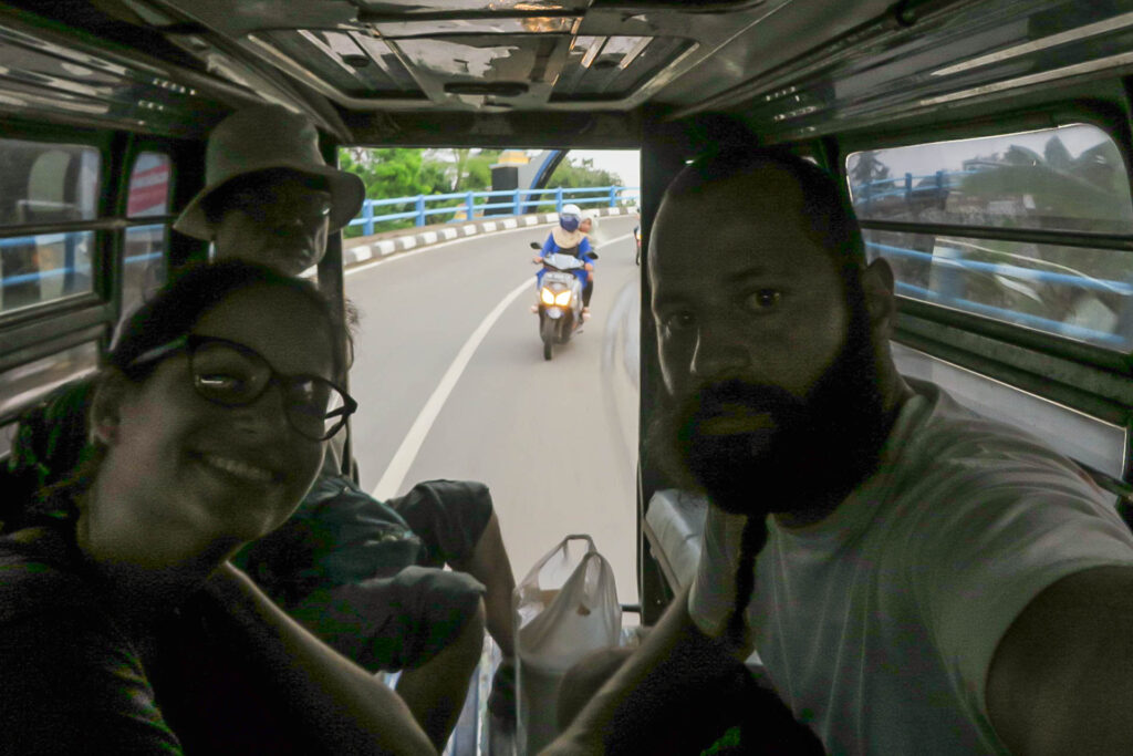 Tiago e Fernanda dentro da minivan em Lombok indo para as Ilhas Gili