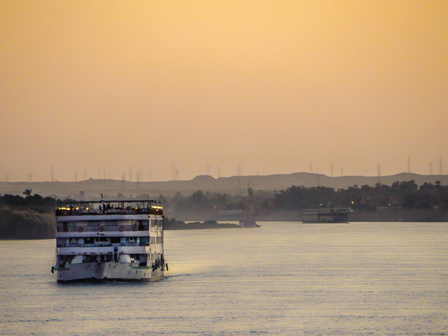Um navio cruzeiro no Nilo ao entardecer com pessoas a bordo