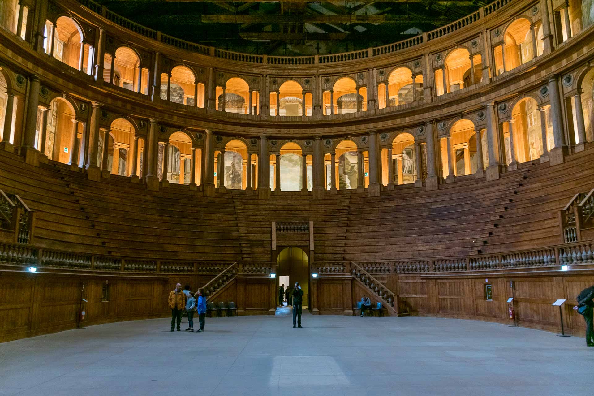 Dentro de um teatro oval com o palco no centro rodeado de assentos