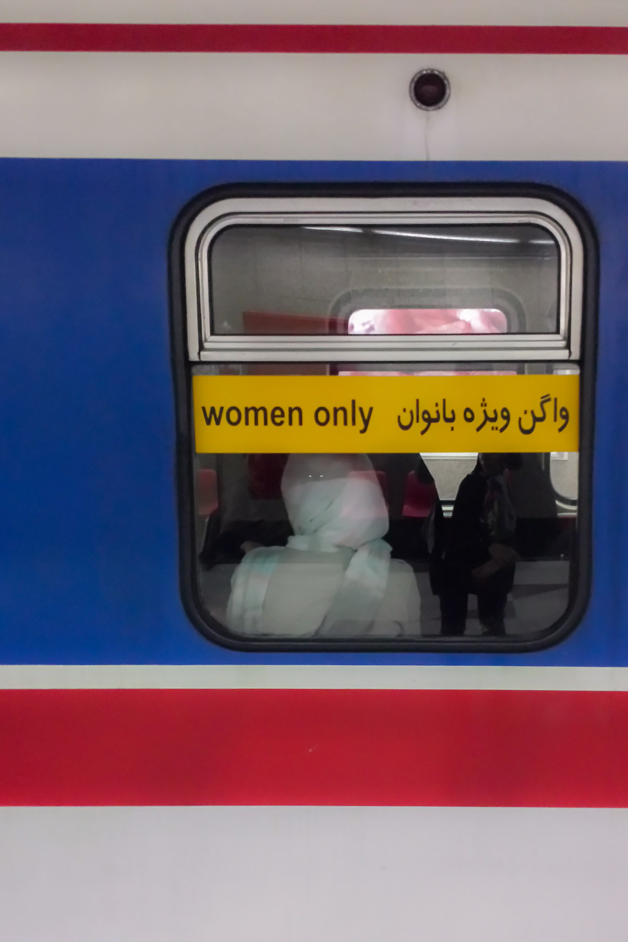 The window of a metro in Tehran saying women only in English and Farsi