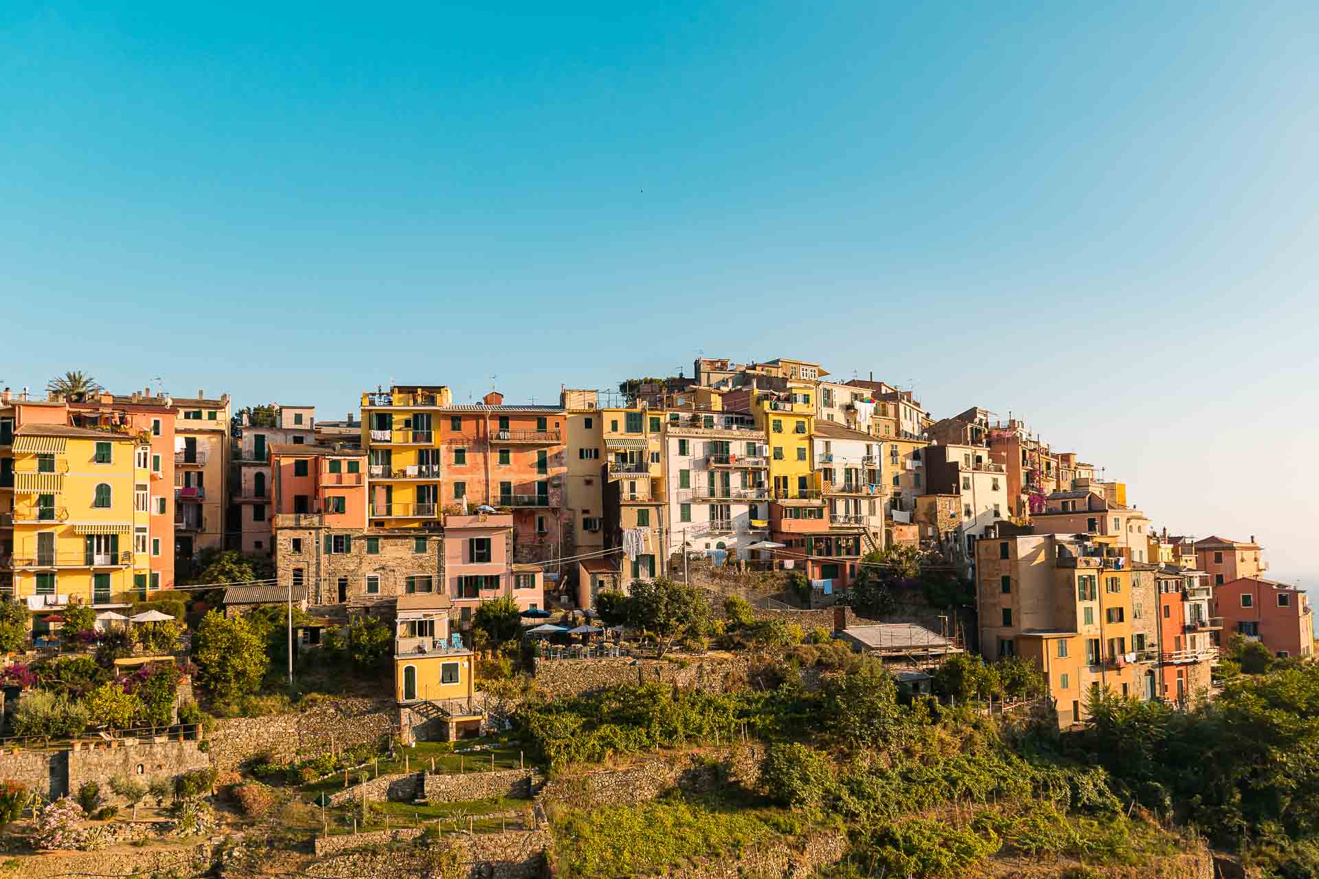 Vista das casas de Corniglia todas coloridas em cima da montanha