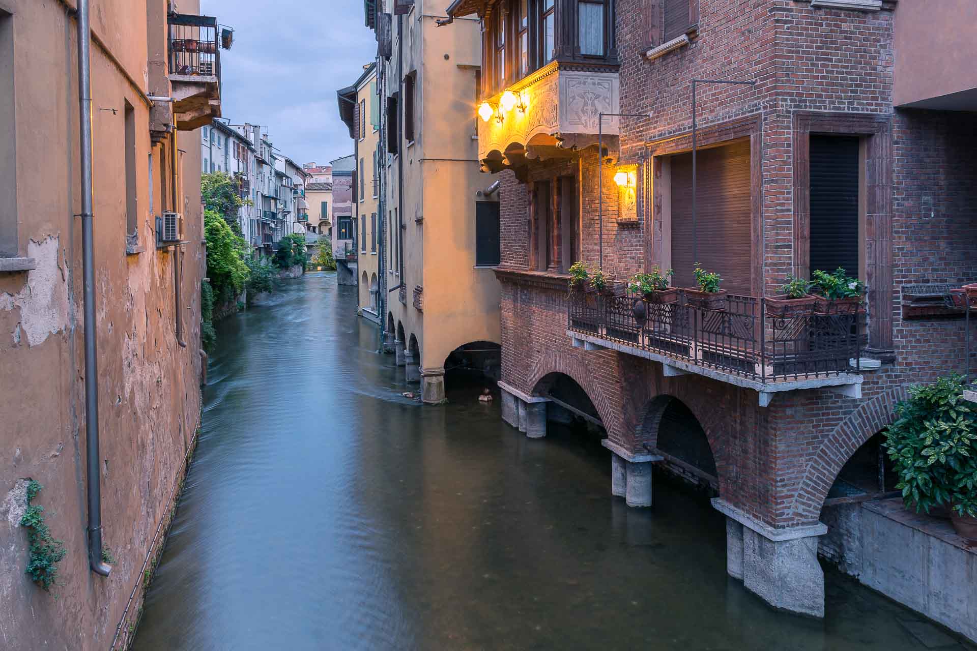 Um canal atravessando a cidade de Mantova na Italia com apartamentos em ambos os lados