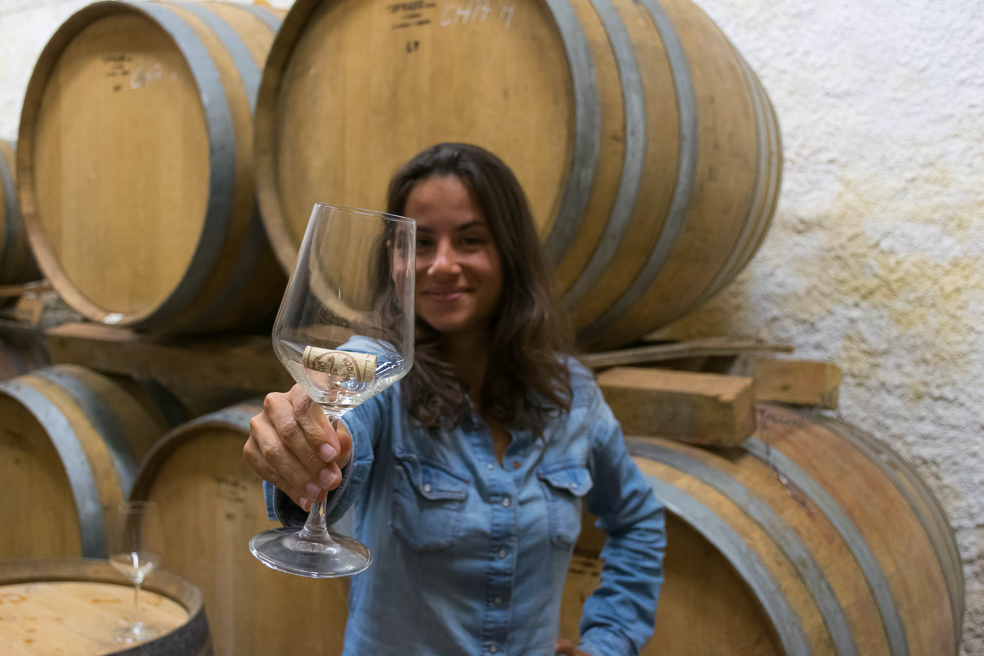 Fe holding a glass of wine in a wine cellar in Brda Slovenia