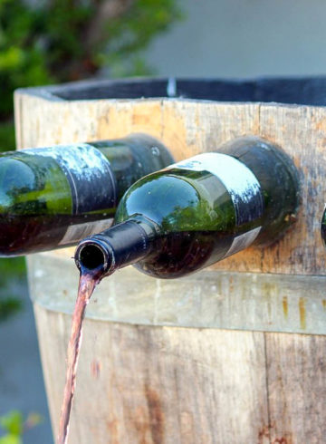 A wine fountain in Italy with wine coming out of bottles