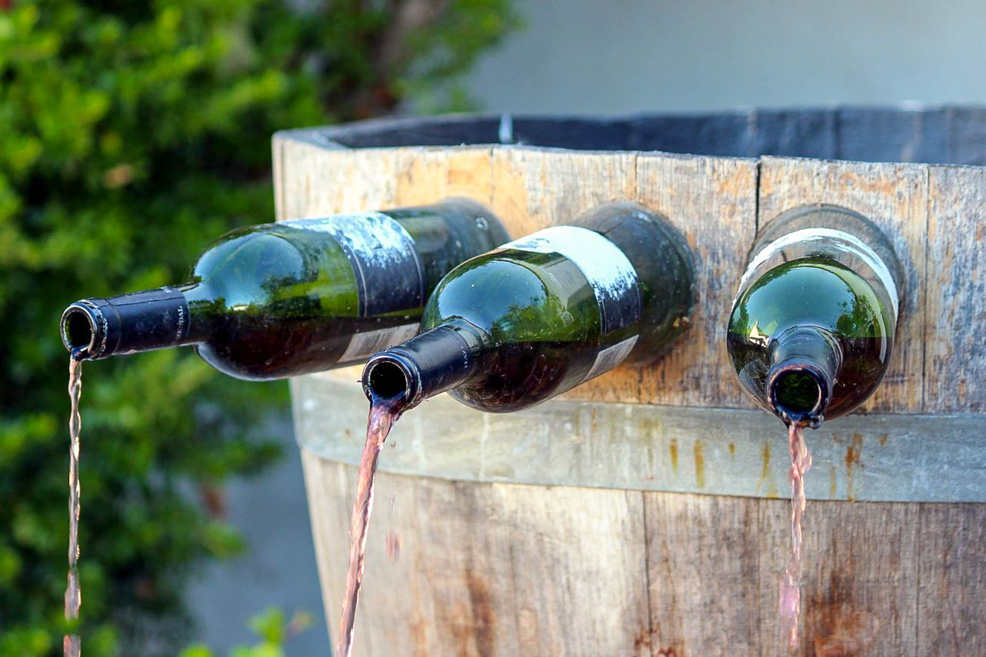 A wine fountain in Italy with wine coming out of bottles