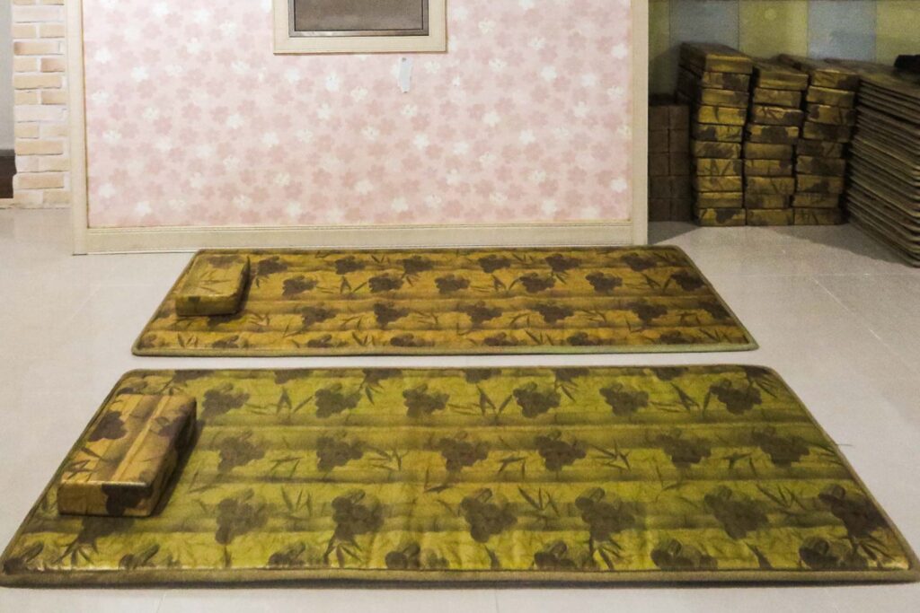 two mats and two Korean pillows laid open on the floor