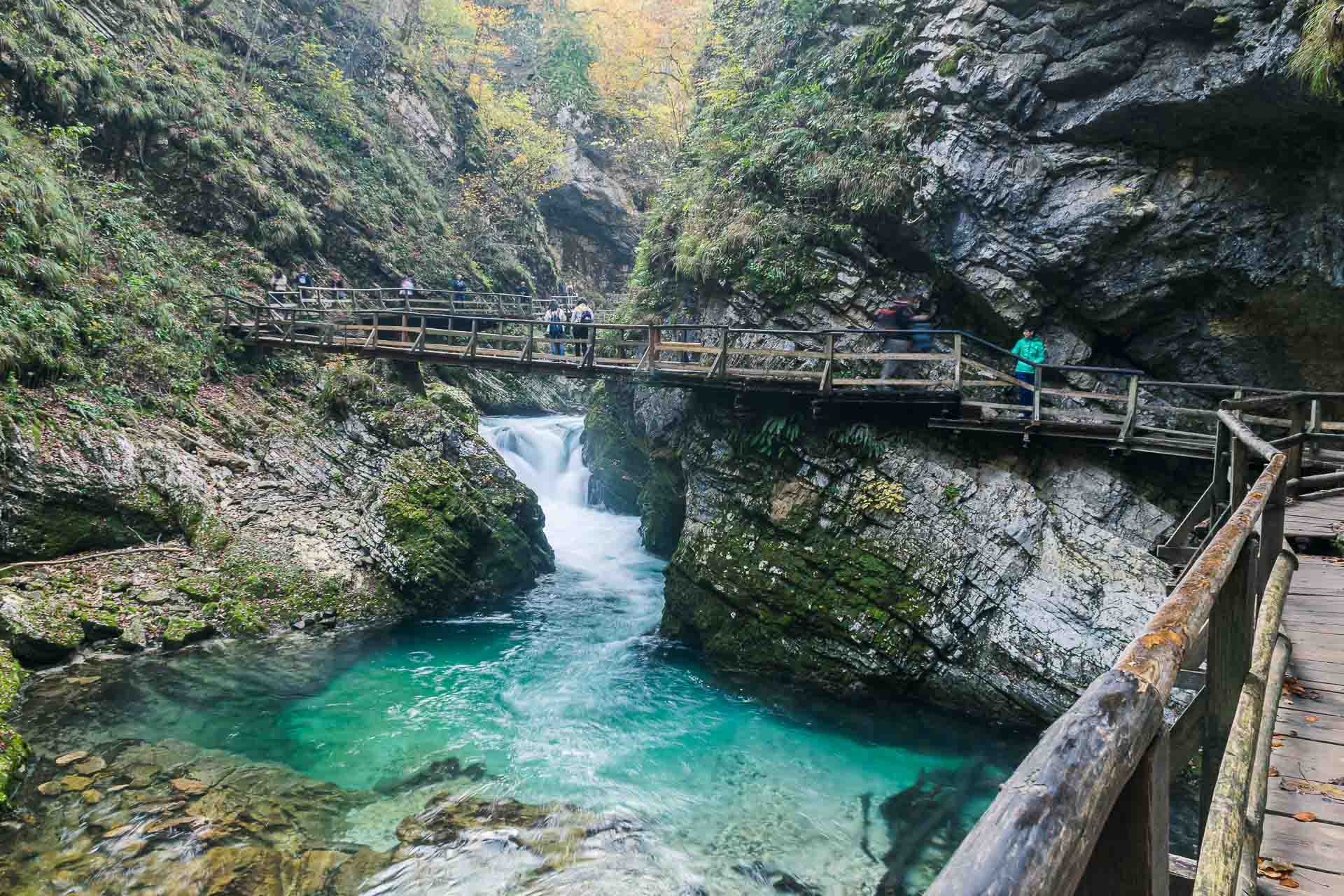 O caminho dentro de Soteska Vintgar passando por cima do rio e entre as paredes de montanha