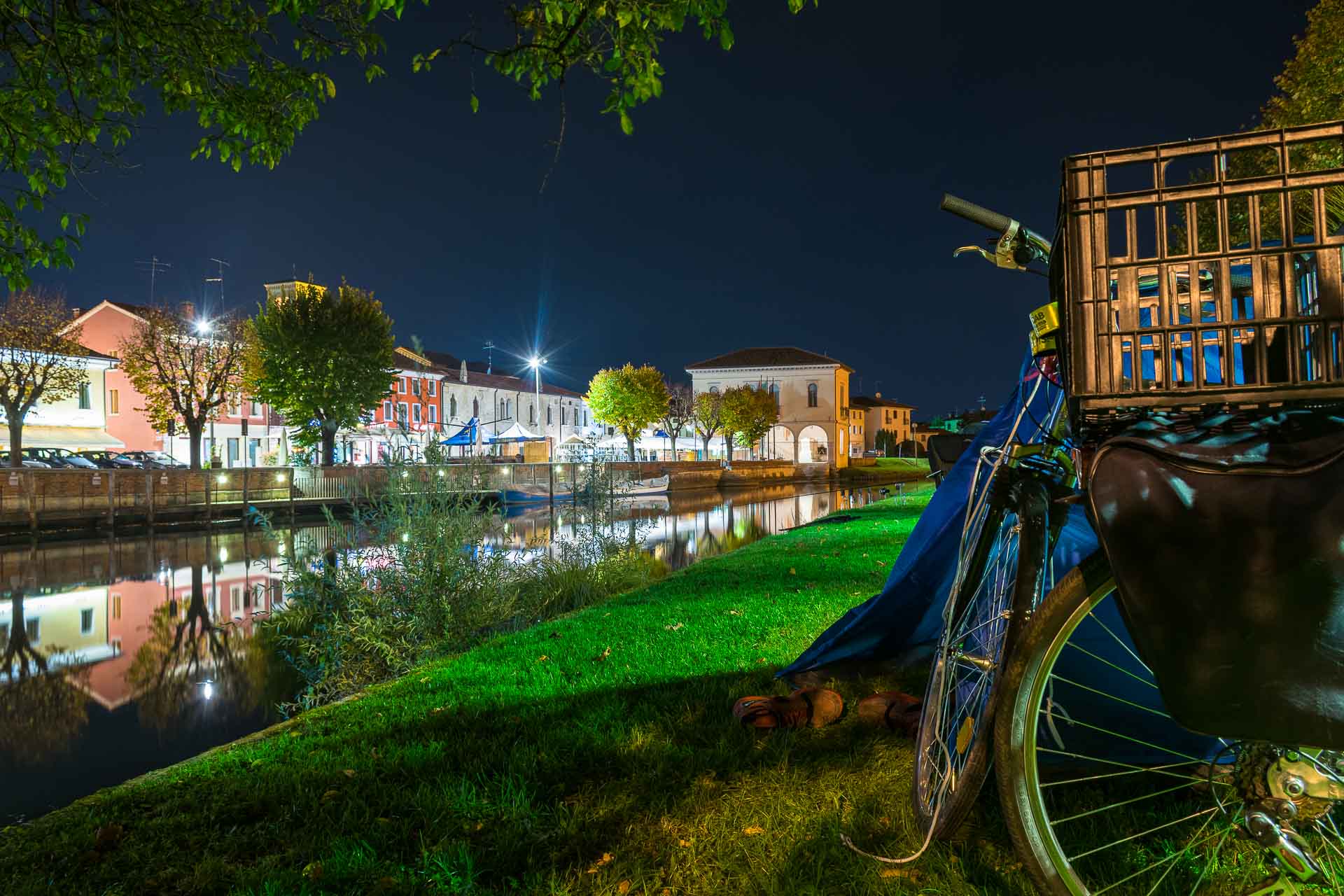 Uma bicicleta ao lado da barraca de acampar na beira do rio da cidade da Itália