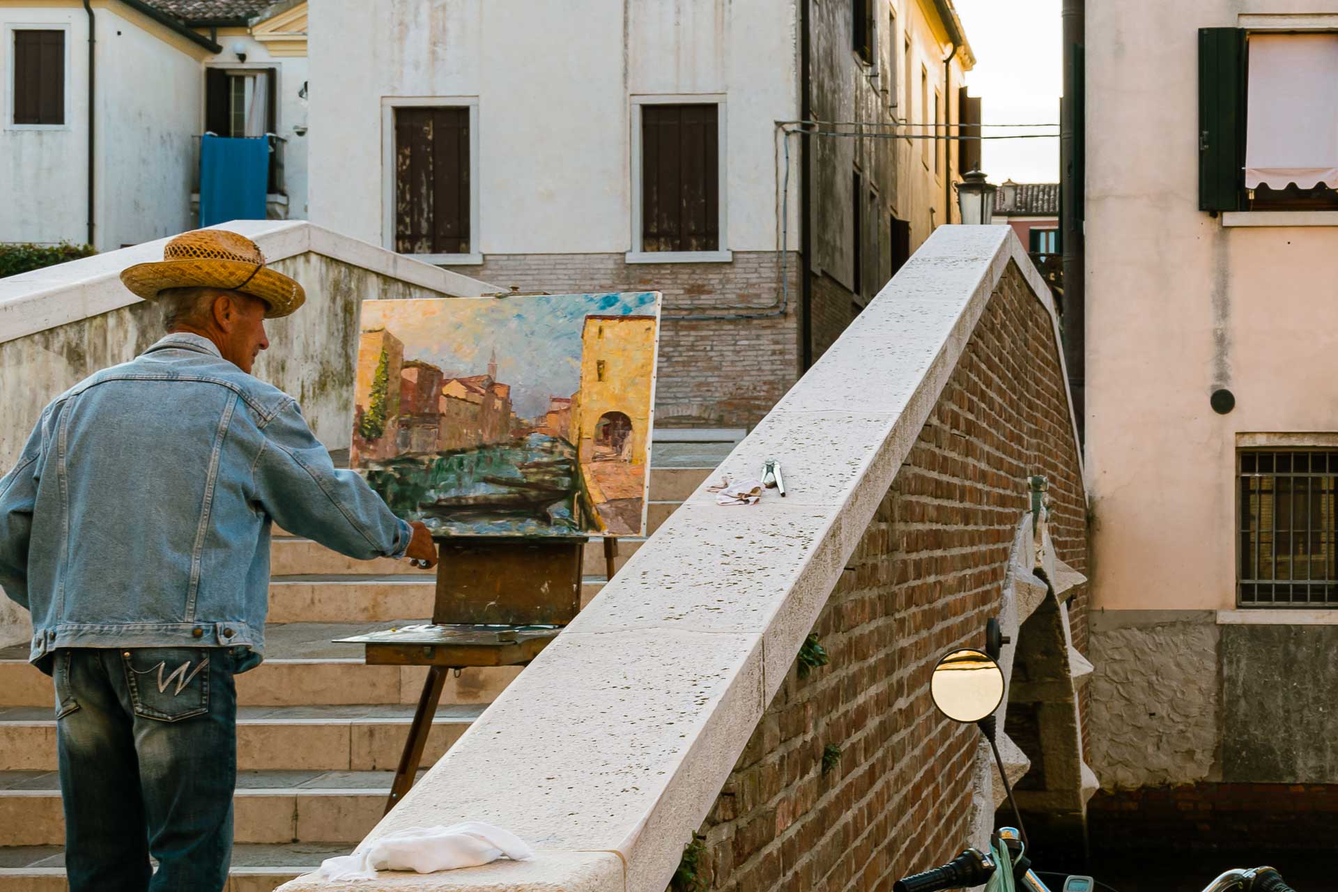 Homem pintando um quadro na ponte em Chioggia