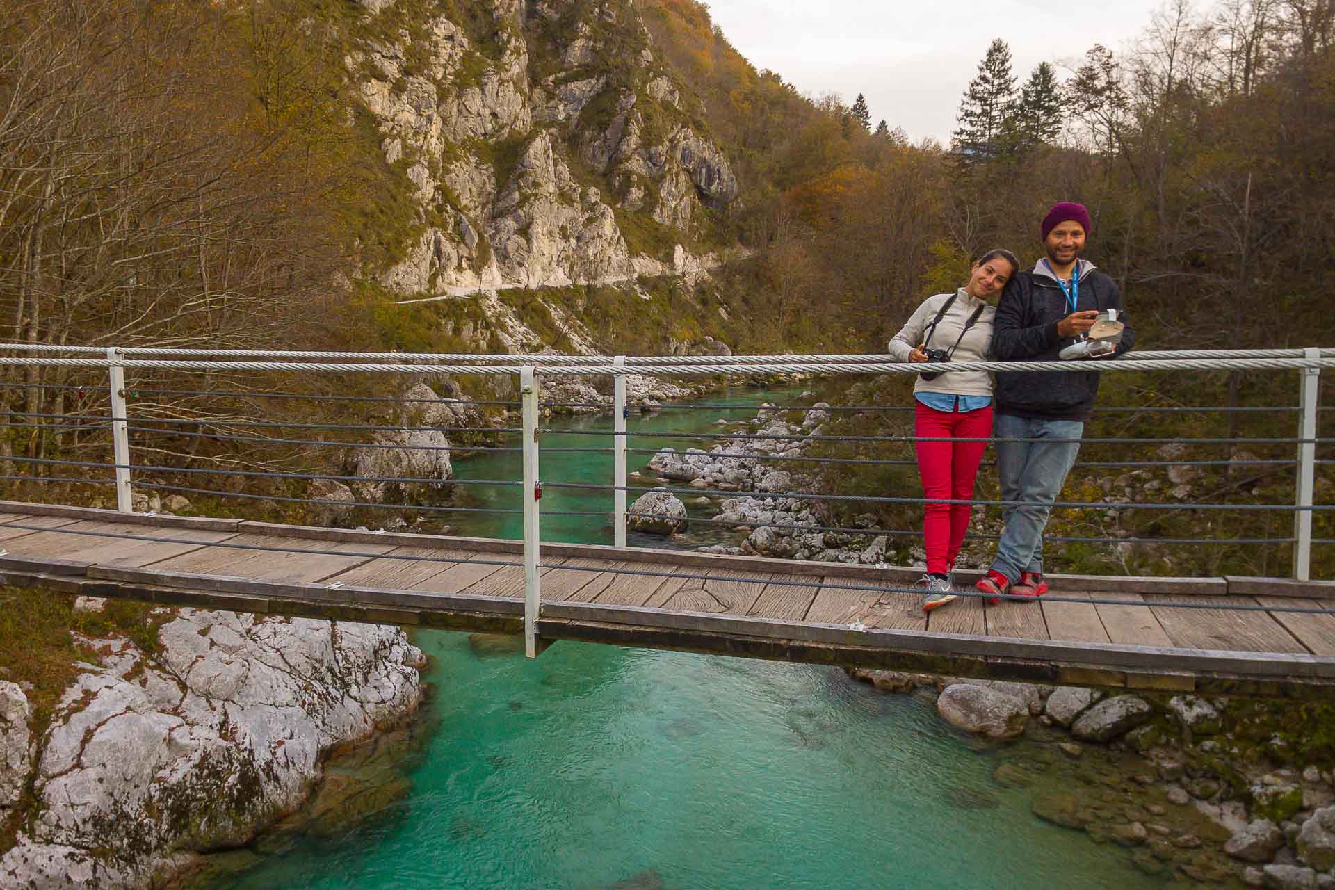 Tiago and Fernanda on a bridge crossing a turquoise colour river in the middle of the nature