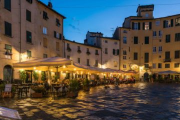 a large square with restaurants at dusk