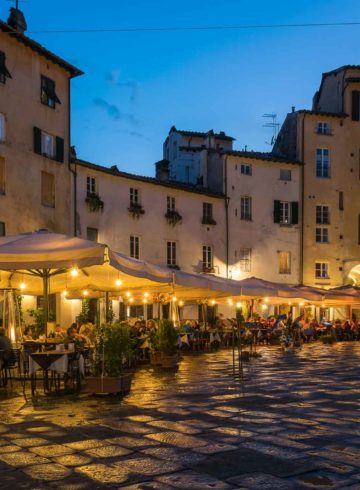 a large square with restaurants at dusk