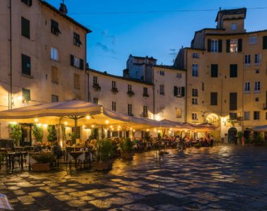 a large square with restaurants at dusk