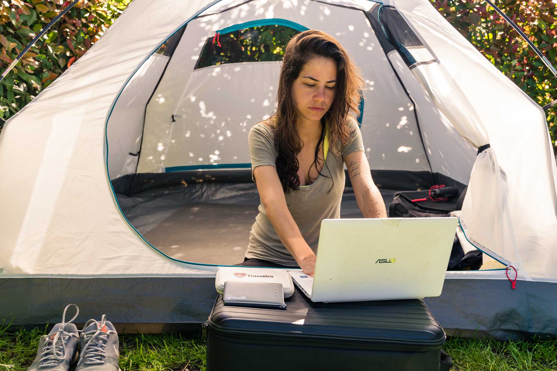 Fernanda usando seu laptop dentro da barraca de acampar