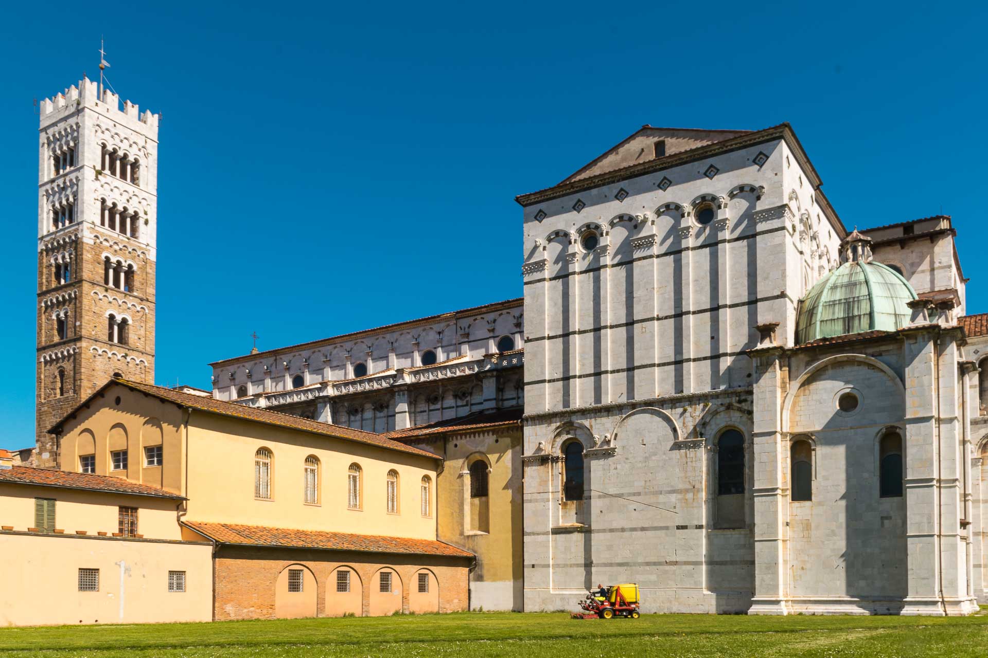 A main cathedral of Lucca near a tower in a blue sky