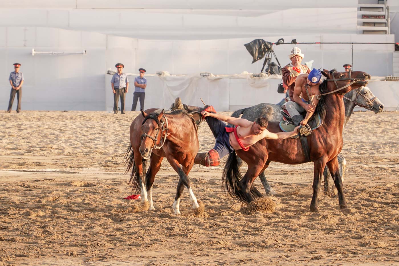 Man falling from a horse during a wrestling match on horses