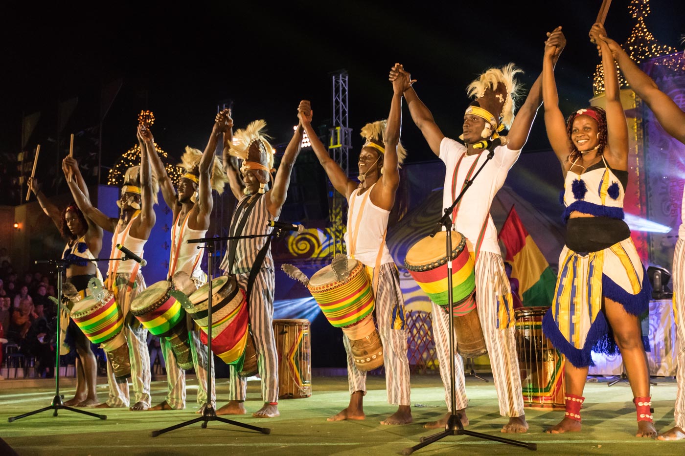 Group of African band holding hands up in the air during a presentation in the World Nomad Games