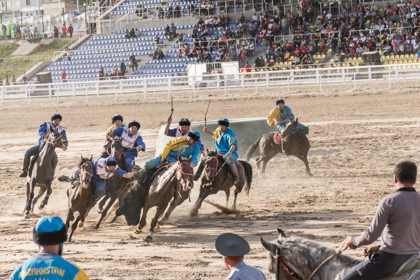 Men riding horses at the Kok Buru sports field at the world nomads competition playing Kok Buru, the dead goat polo