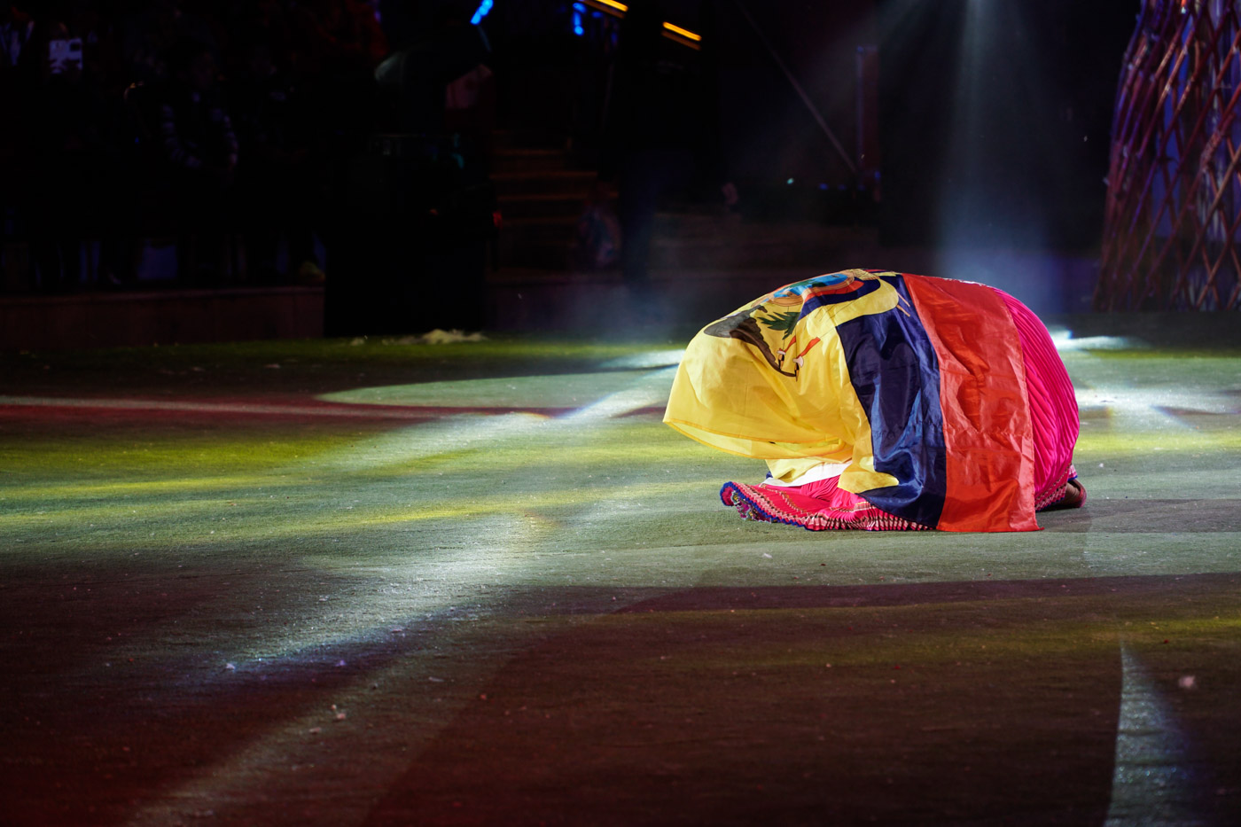 A woman in a fetal position involved by the Venezuelan flag