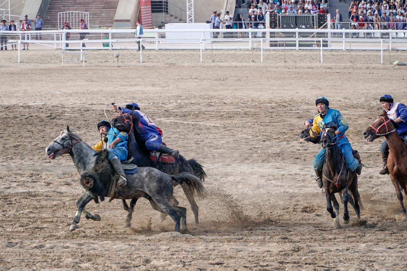 Man holding the dead goat while riding a horse scaping from opponent at the World nomad Games in a world nomads competition