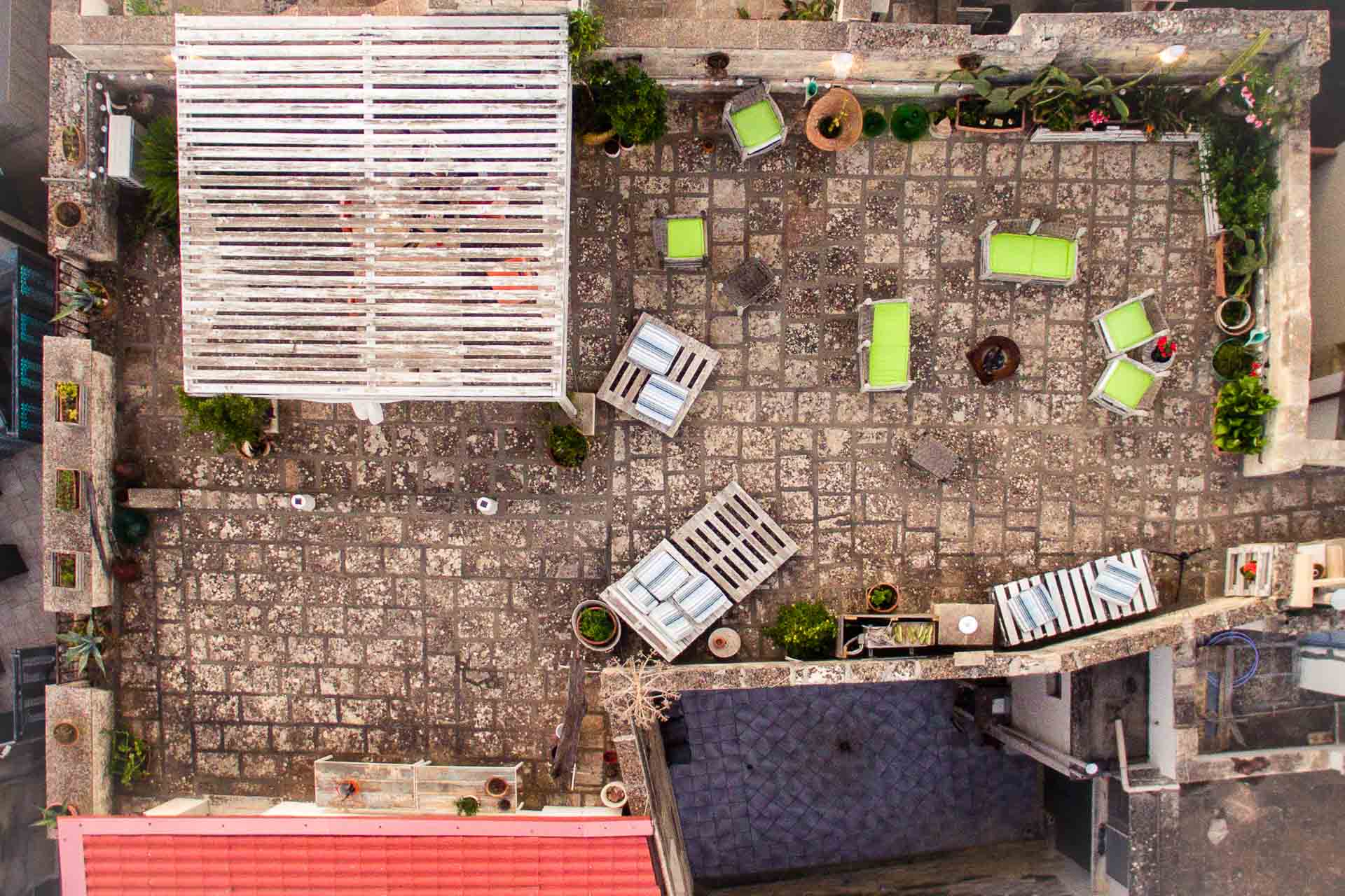 an overhead view of the terrace with seats, a roof and a fire place