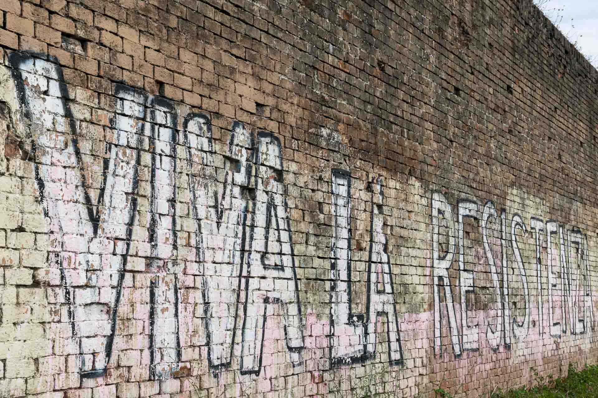 Um muro com grafite escrito Viva La Resistenza
