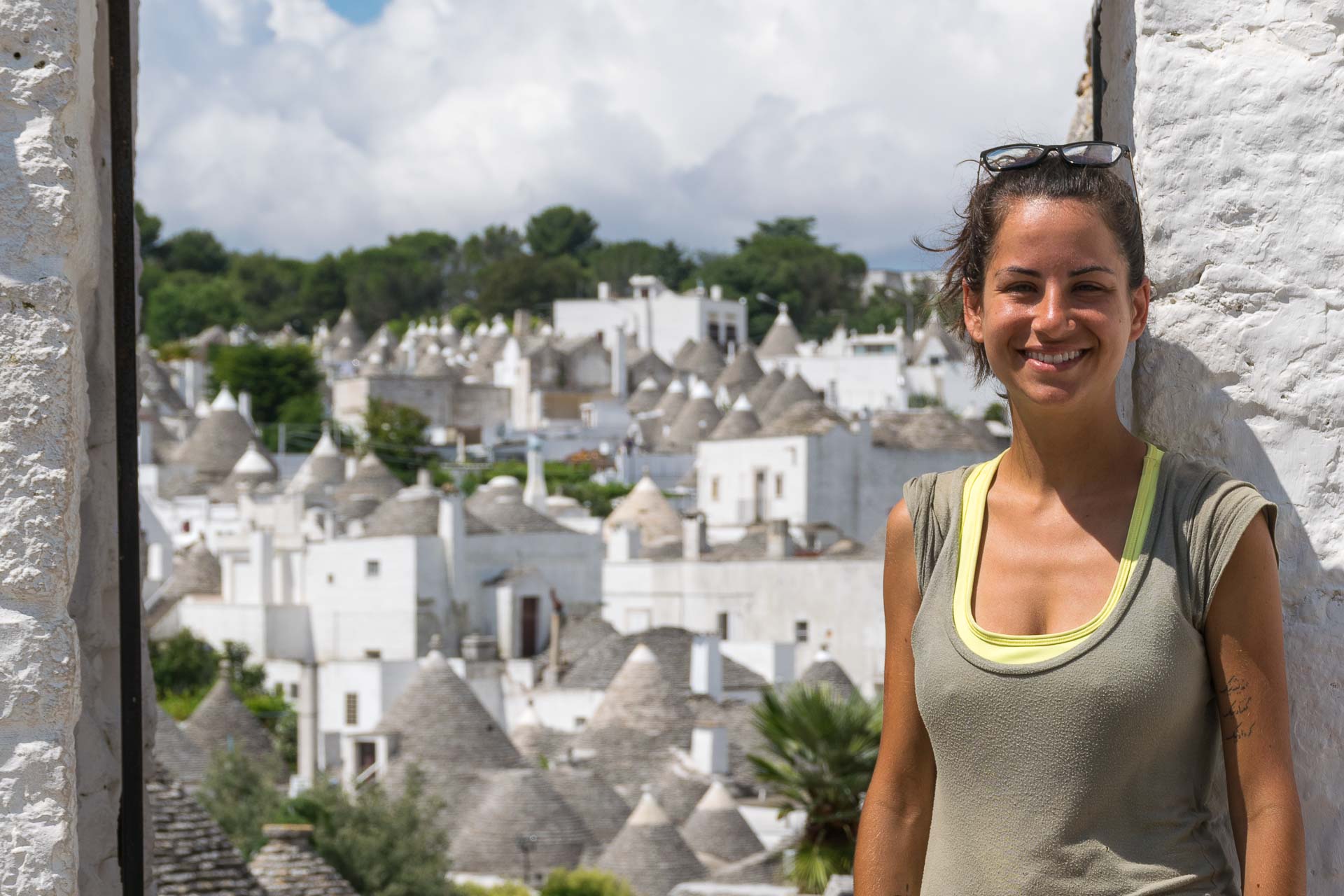 Fernanda in front of an arch showing all the trulli houses in alberobello italy