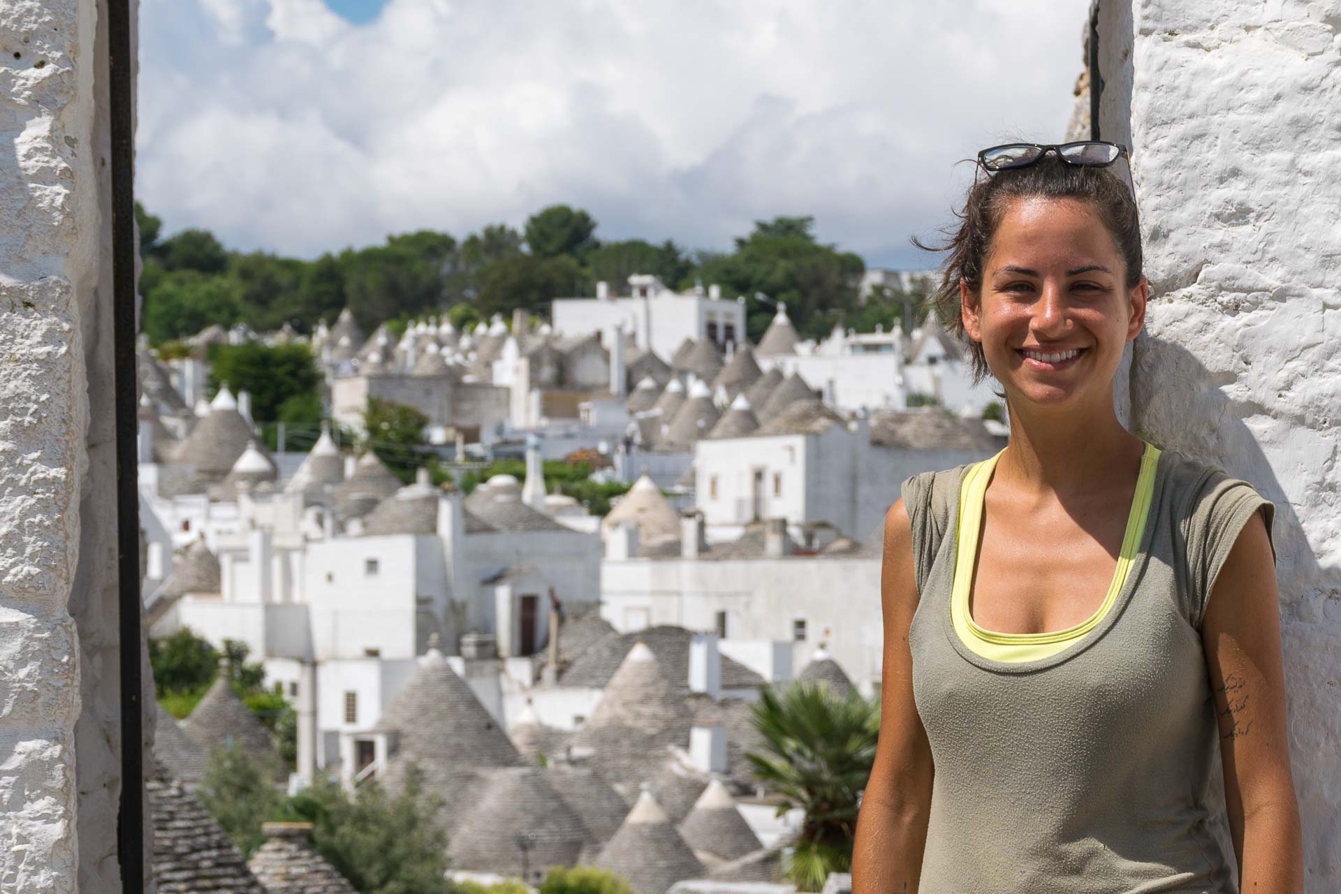 Fernanda na frente de uma entrada mostrando todas os trulli de alberobello na Itália