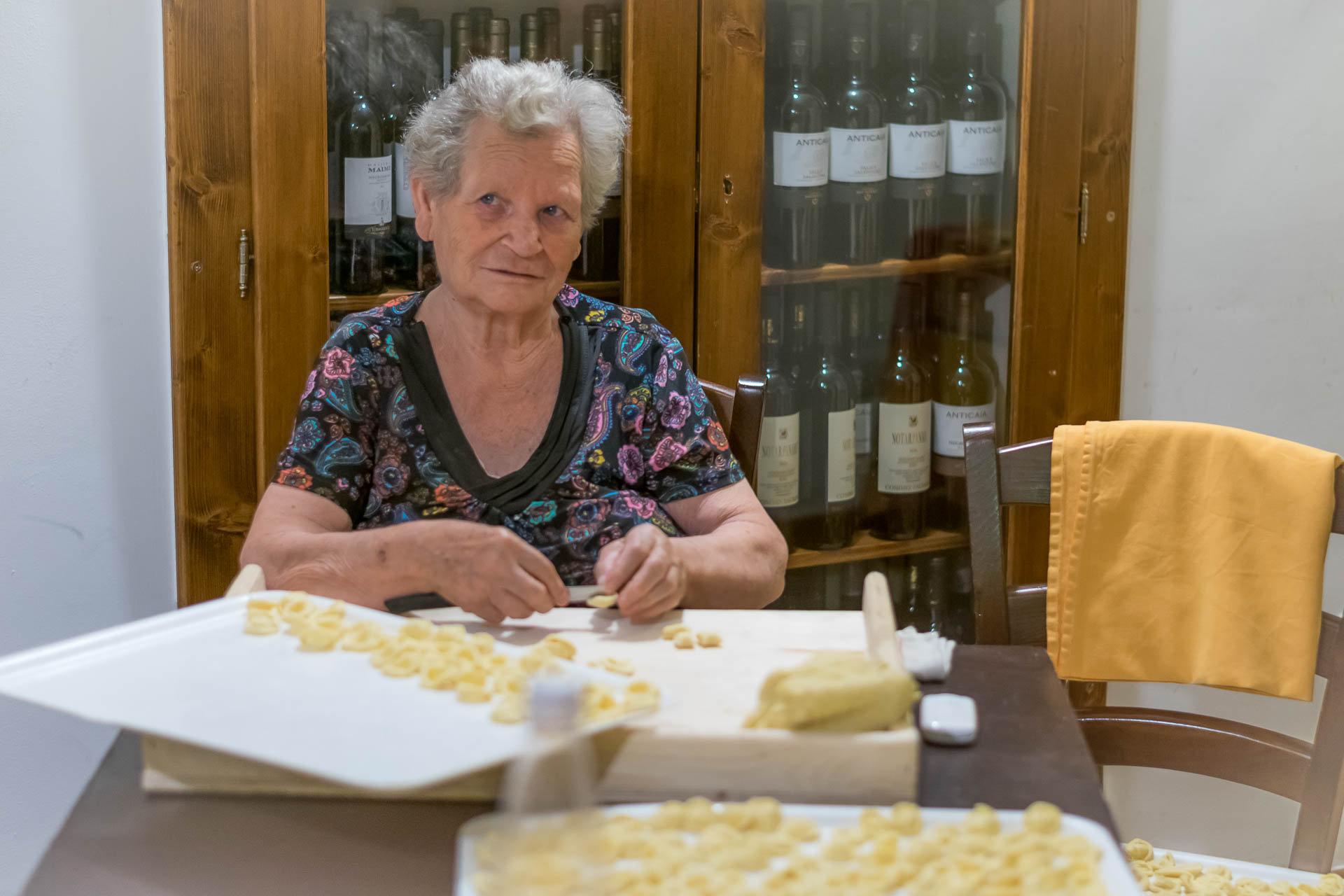 A mama italiana preparando pasta fresca na sala do restaurante