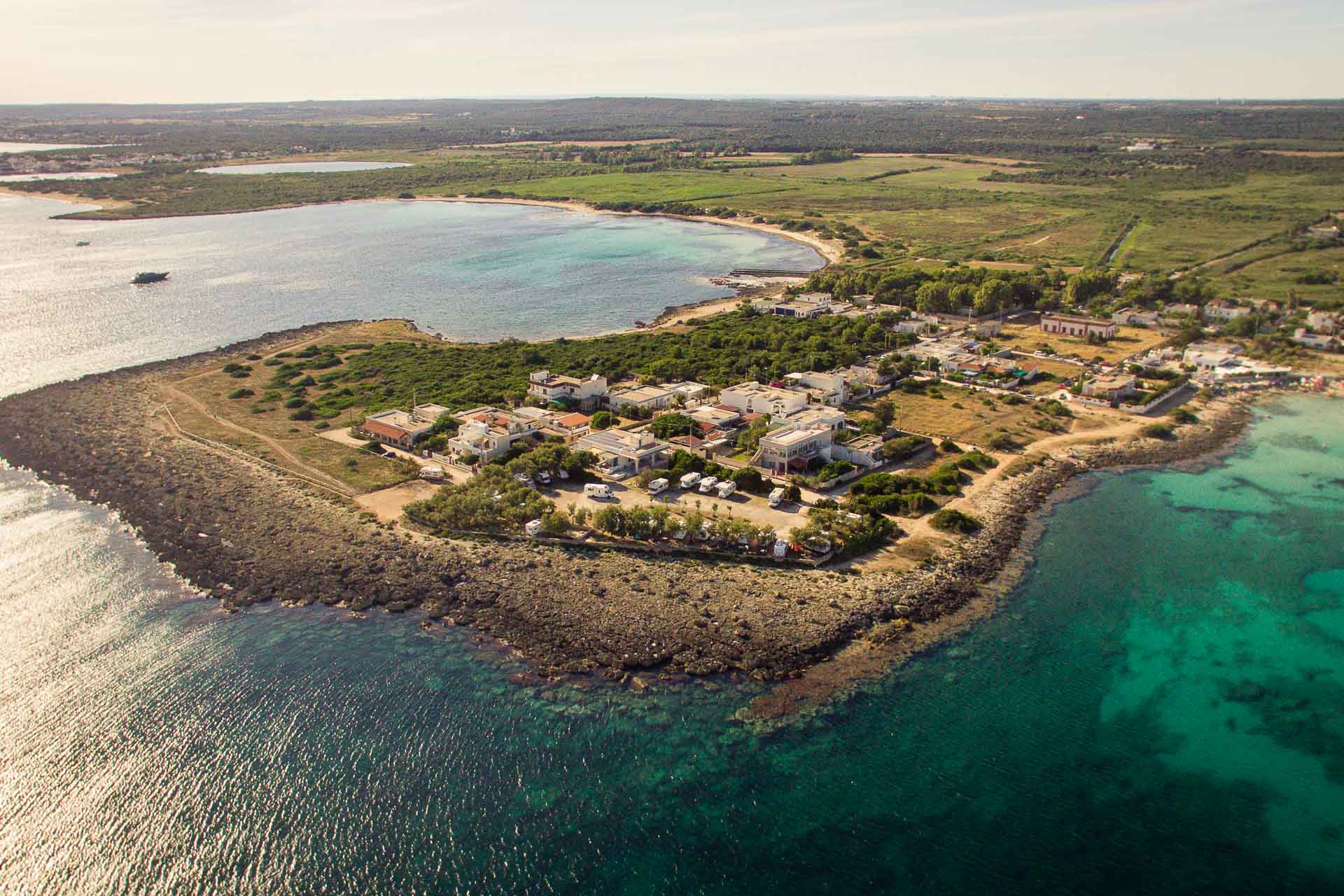 Aerial view of Punta Prosciutto, a islet surrounded by the clear green sea water