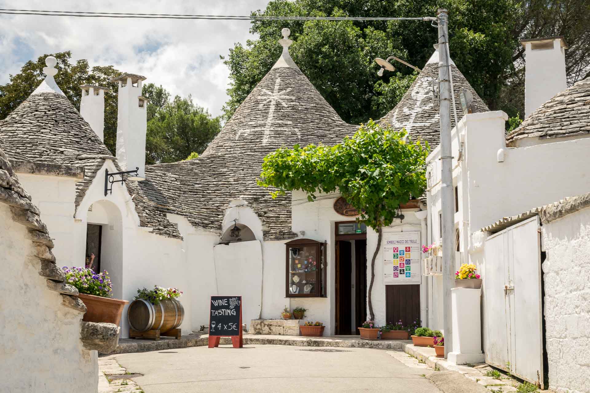 A dead end road with many trulli houses, one of them changed into a restaurant with a menu on the door