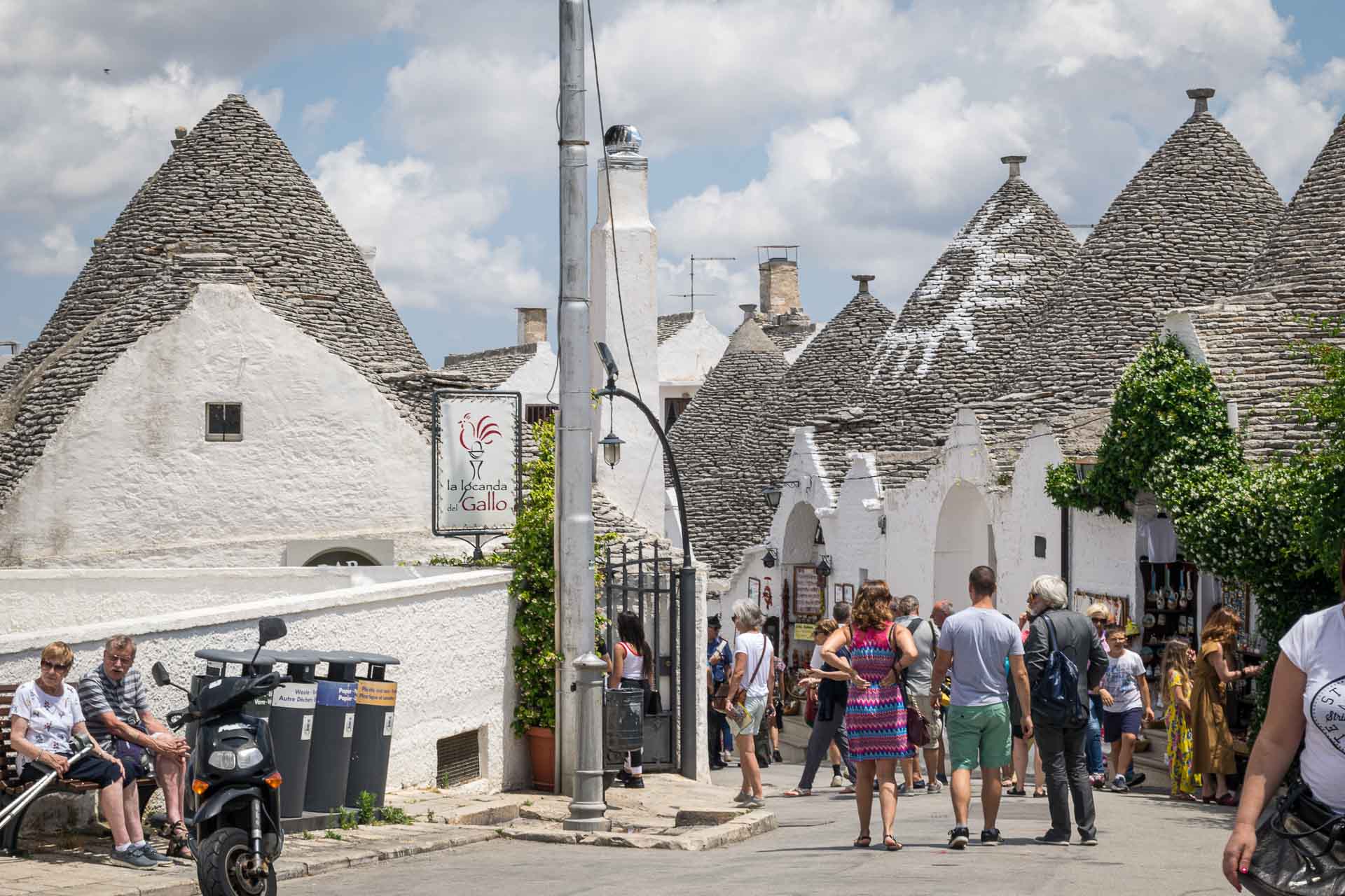 tourists in the streets of Alberobello in Puglia with trulli houses around