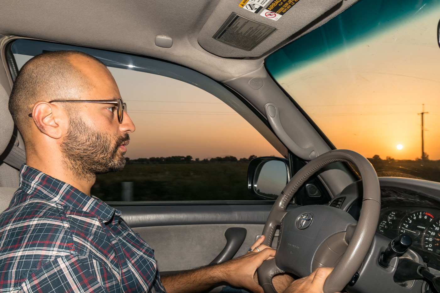 Tiago driving in Kyrgyzstan with the sun setting in the horizon