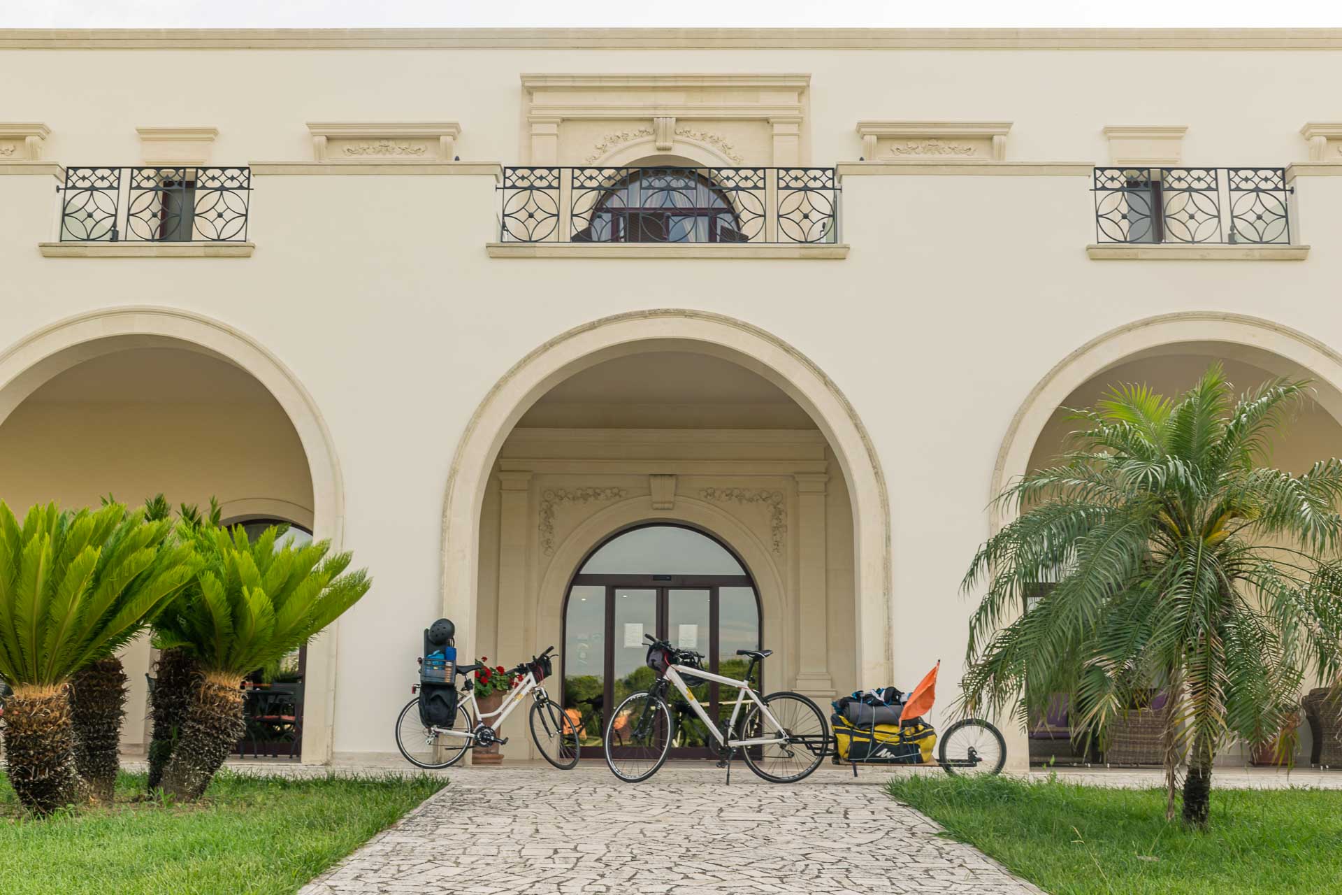 The entrance of the Masseria in Puglia with two bikes parked in the front of a large arch