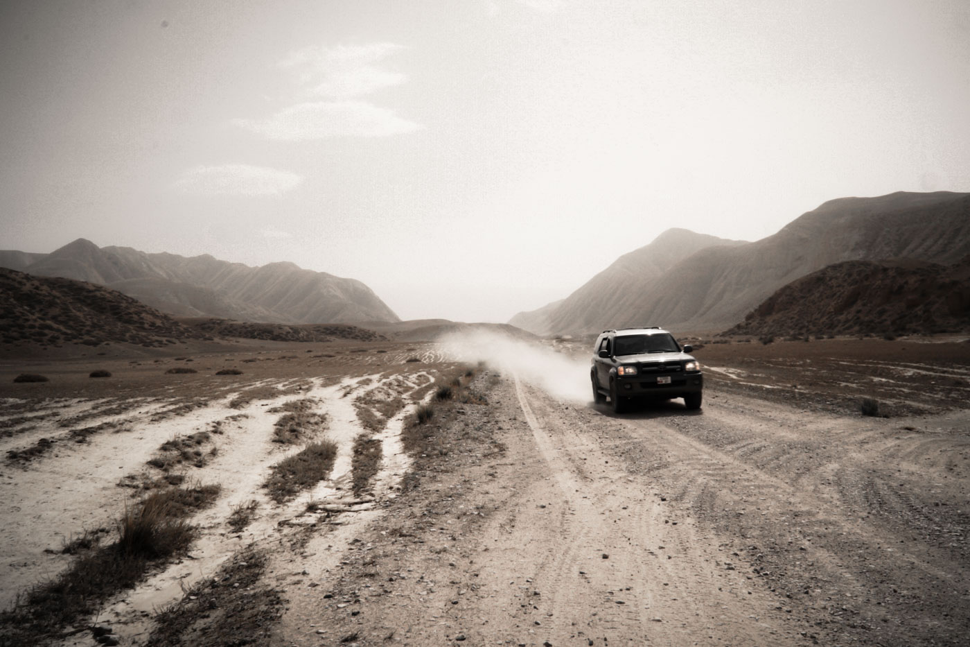 Driving in Kyrgyzstan through dirt roads in between mountains